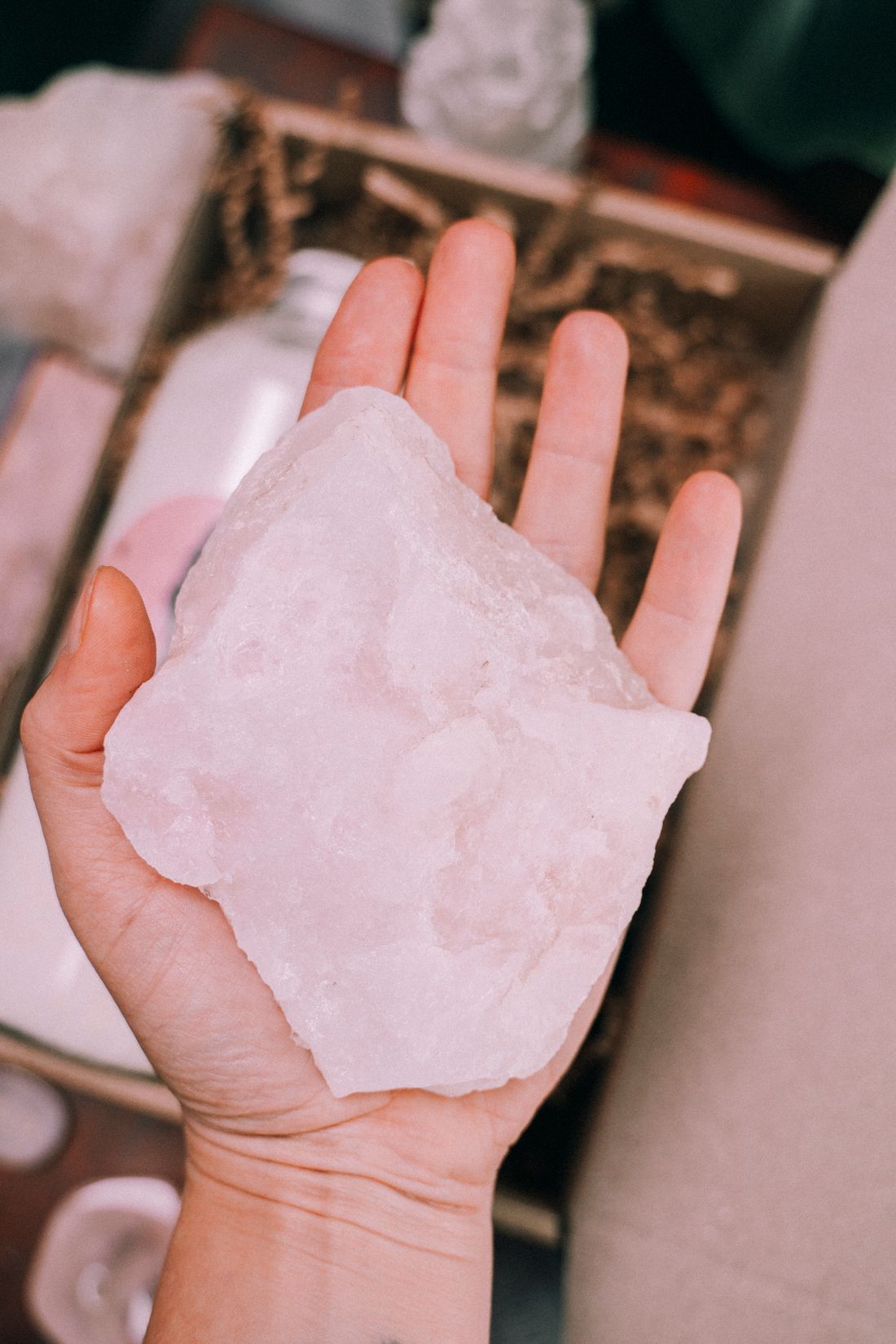A natural pale crystal resting in an open hand